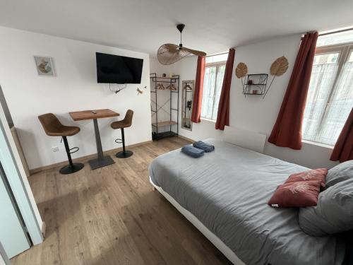 a bedroom with a bed and a desk and a television at ecuires 1 in Écuires