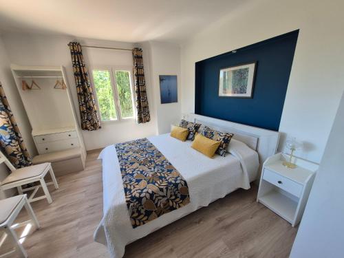 a bedroom with a bed with a blue wall at Montèze Paradis in Saint-Christol-lès-Alès