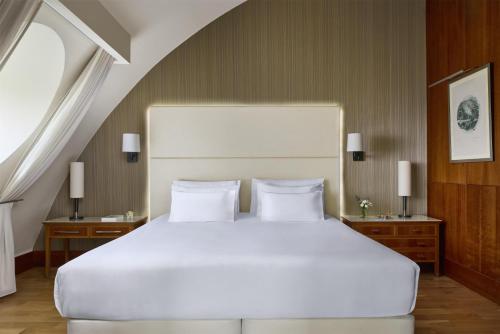 a bedroom with a large white bed and two night stands at NH Collection Vigo in Vigo