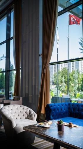 a living room with a table and a couch and a window at Radisson Blu Hotel, Diyarbakir in Diyarbakır