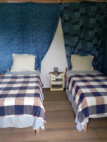 two beds sitting next to each other in a room at Casinha da Roça Java in Santa Adelaide
