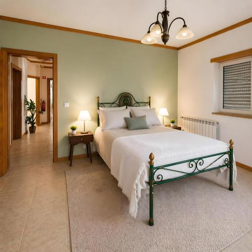 a bedroom with a large bed and two lamps at Caramulo Valley View in Campo de Besteiros