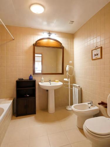 a bathroom with a sink and a toilet and a mirror at Caramulo Valley View in Campo de Besteiros