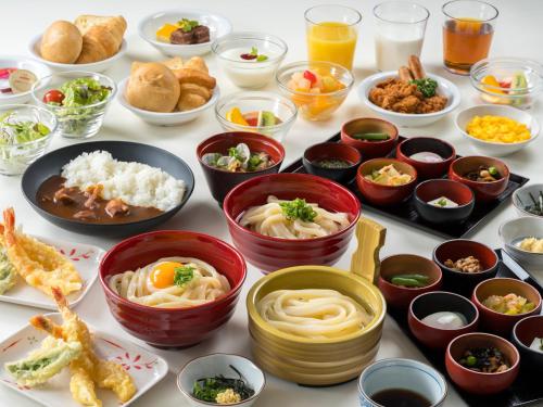 a table topped with bowls of food and plates of food at Dormy Inn Takamatsu in Takamatsu