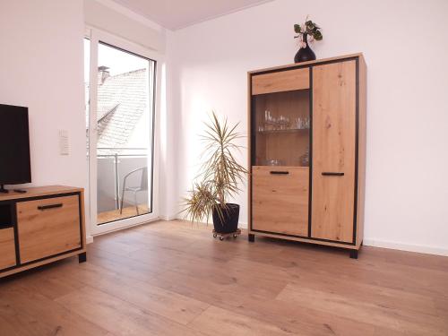 a living room with a wooden cabinet and a window at Komfort-Ferienwohnung gierskopp.pur in Olsberg