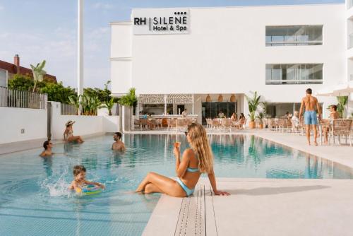 Eine Frau und ein Kind sitzen in einem Schwimmbecken in der Unterkunft RH Silene Hotel & Spa 4 Sup in Castellón de la Plana