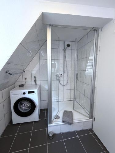 a bathroom with a shower and a washing machine at Marktplatzapartment 2 in Höxter