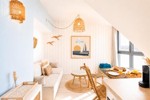 a living room with a table and a couch at Appart'Hôtel & Spa "Les Voiles" Le Houat in Carnac