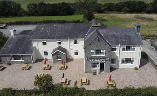 an aerial view of a large white house with a patio at Ty Dderw in Moelfre