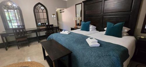 a hotel room with two beds and a table with towels at Phumula Farm Guesthouse in Nhlangano