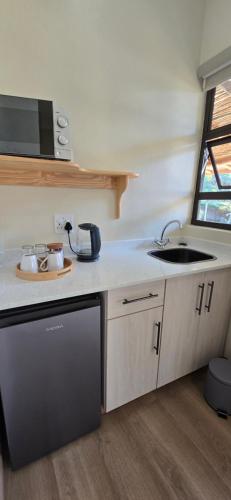 a small kitchen with a sink and a counter at Phumula Farm Guesthouse in Nhlangano