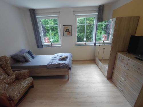 a room with a bed and a couch and windows at Alte Mühle in Holzminden