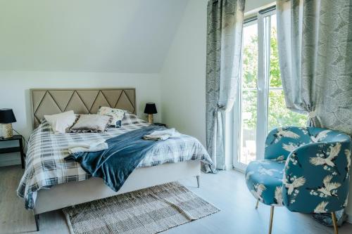 a bedroom with a bed and a chair and a window at Baltic Breeze & Spa in Władysławowo