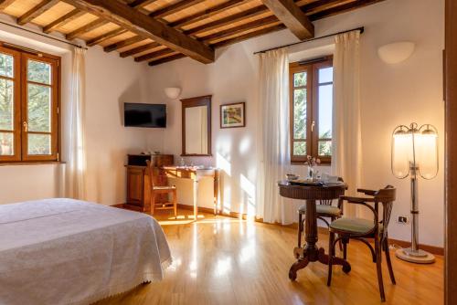 a bedroom with a bed and a table and a desk at Hotel La Pace in Asciano