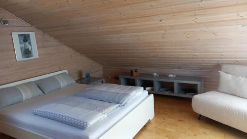 a bedroom with a white bed and a chair at FeWo Wardersee in Rohlsdorf