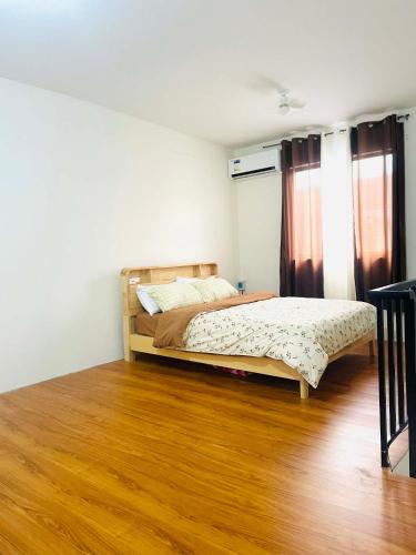 a bedroom with a bed and a wooden floor at Sta Cruz Laguna Transient House in Santa Cruz