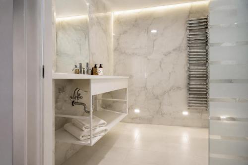 a bathroom with white marble walls and a shower at Aparthotel František in Světlá nad Sázavou