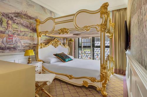 a bedroom with a gold canopy bed and a desk at The Serangoon House Little India, Singapore, a Tribute Portfolio Hotel in Singapore