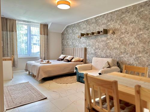 a living room with a bed and a couch at Bocian Apartamenty in Krynica Zdrój