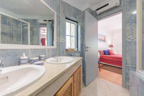 a bathroom with two sinks and a room with a bed at Villa Praia Verde - Beach & Nature in Praia Verde