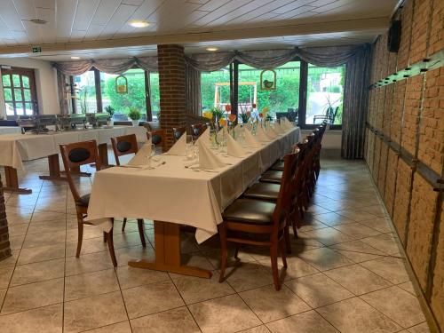 a dining room with a long table and chairs at Hotel Pension Haus Stork in Holzhausen