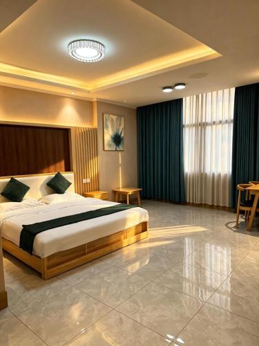 a hotel room with a bed and a table at zhiyuanta hotel in Vientiane