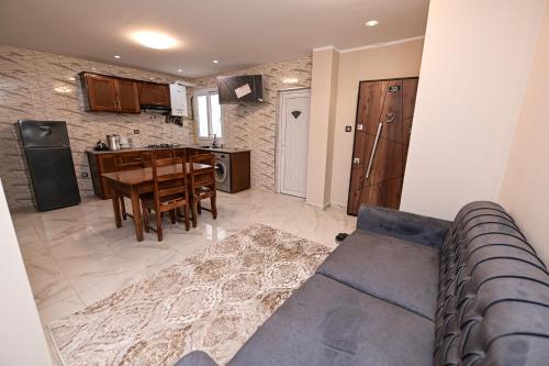 a living room with a blue couch and a kitchen at Hostel Bouchair Centre Ville Jijel in Jijel
