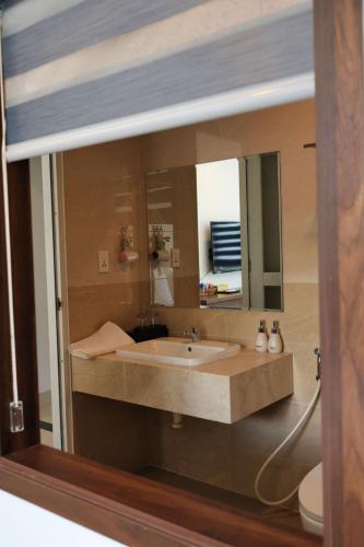a bathroom with a sink and a mirror at Lucky Hotel in Phước Lai