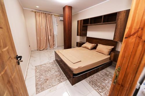 a bedroom with a bed with a wooden headboard at Hostel Bouchair Centre Ville Jijel in Jijel