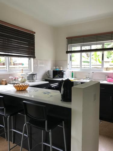 a kitchen with a large island with bar stools at Flower Garden Self-Catering Apartments in Beau Vallon