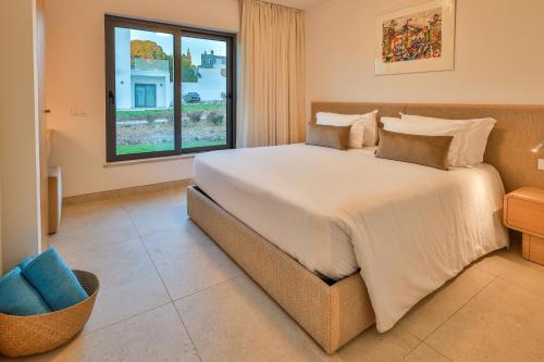 a bedroom with a large bed and a window at Primelife Carvoeiro in Praia do Carvoeiro