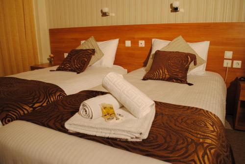 Hotel Ideal في بيرايوس: سريرين في غرفة الفندق عليها مناشف