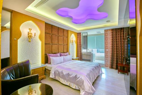 sypialnia z łóżkiem i fioletowym sufitem w obiekcie Gold Motel w mieście Puxin