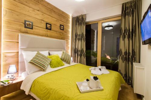 ザコパネにあるMała Łąkaのベッドルーム1室(黄色のベッド1台、トレイ2つ付)