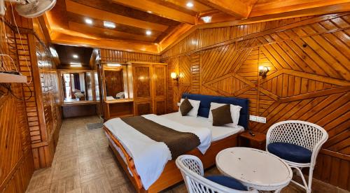 a bedroom with a bed and a table and chairs at Nainital Hill View Boho in Nainital