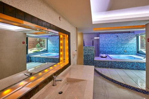 łazienka z 2 wannami i dużym lustrem w obiekcie Gold Motel w mieście Puxin