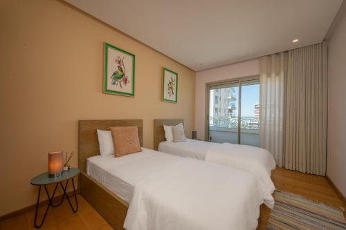 two beds in a room with a window at anfa Louise in Casablanca