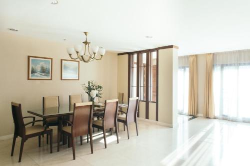 a dining room with a table and chairs at Thomson Residence Hotel in Bangkok