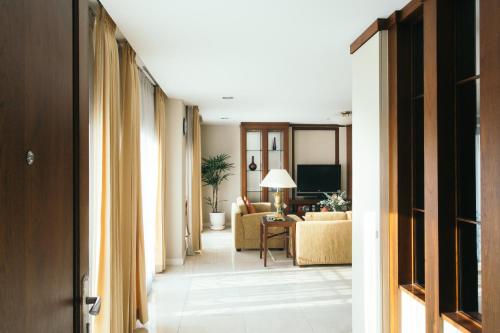 a hallway with a living room with a couch at Thomson Residence Hotel in Bangkok