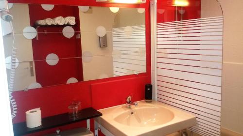 a bathroom with a sink and a mirror at Le Merle Blanc Hôtel Logis in Digoin