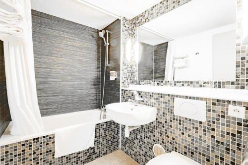 a bathroom with a sink and a tub and a toilet at Urban House in Roubaix
