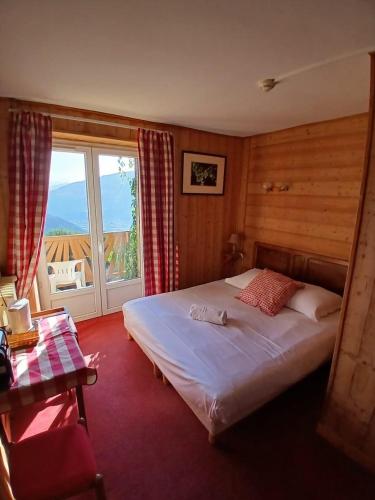 a bedroom with a bed and a large window at Auberge du Belvédère in Séez