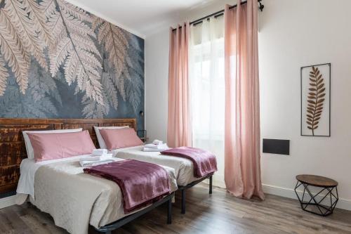 a bedroom with two beds and a large window at BluesHouse La Fenice in Bologna