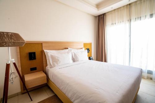 a bedroom with a large white bed and a window at Zephyr Saidia in Saïdia