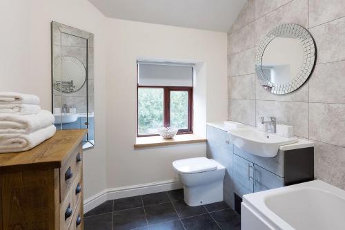 a bathroom with a sink and a toilet and a mirror at Vera's cottage in Edale
