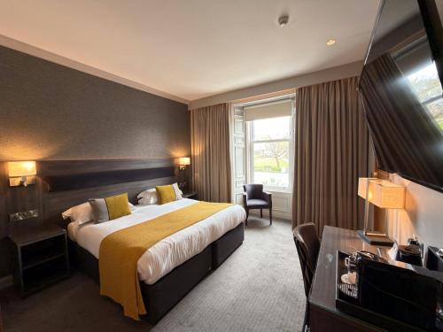 a hotel room with a bed and a television at The Angus Hotel & Spa by Compass Hospitality in Blairgowrie