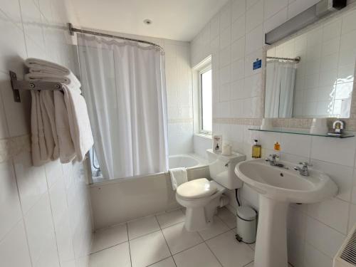 a white bathroom with a toilet and a sink at The Angus Hotel & Spa by Compass Hospitality in Blairgowrie