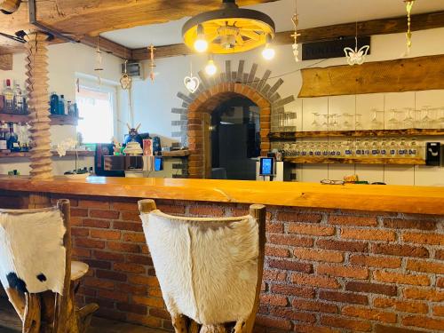 a bar with two chairs at a brick wall at Franzlhof Chalets in Stainz