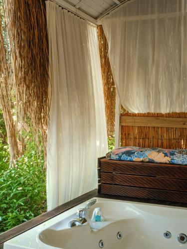a bathroom with a bath tub and a bed at Suna Sun Hotel - Adult Only in Kaş