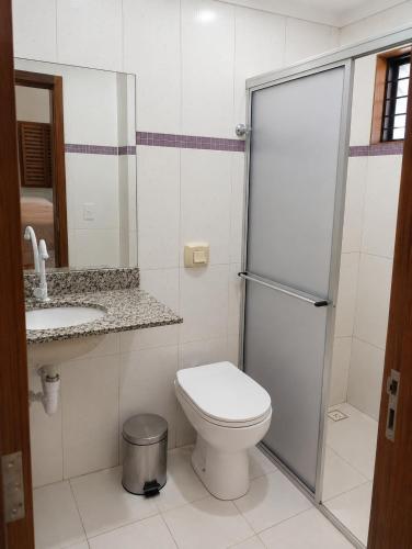 a bathroom with a toilet and a sink and a shower at Balcony house in Campo Grande